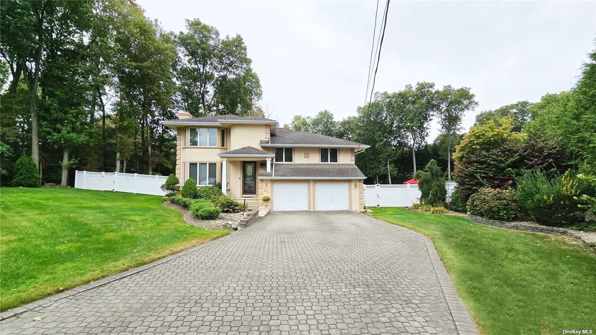 a front view of a house with a yard and trees