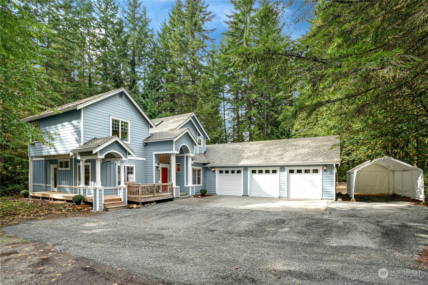 a view of a house with a yard and large trees