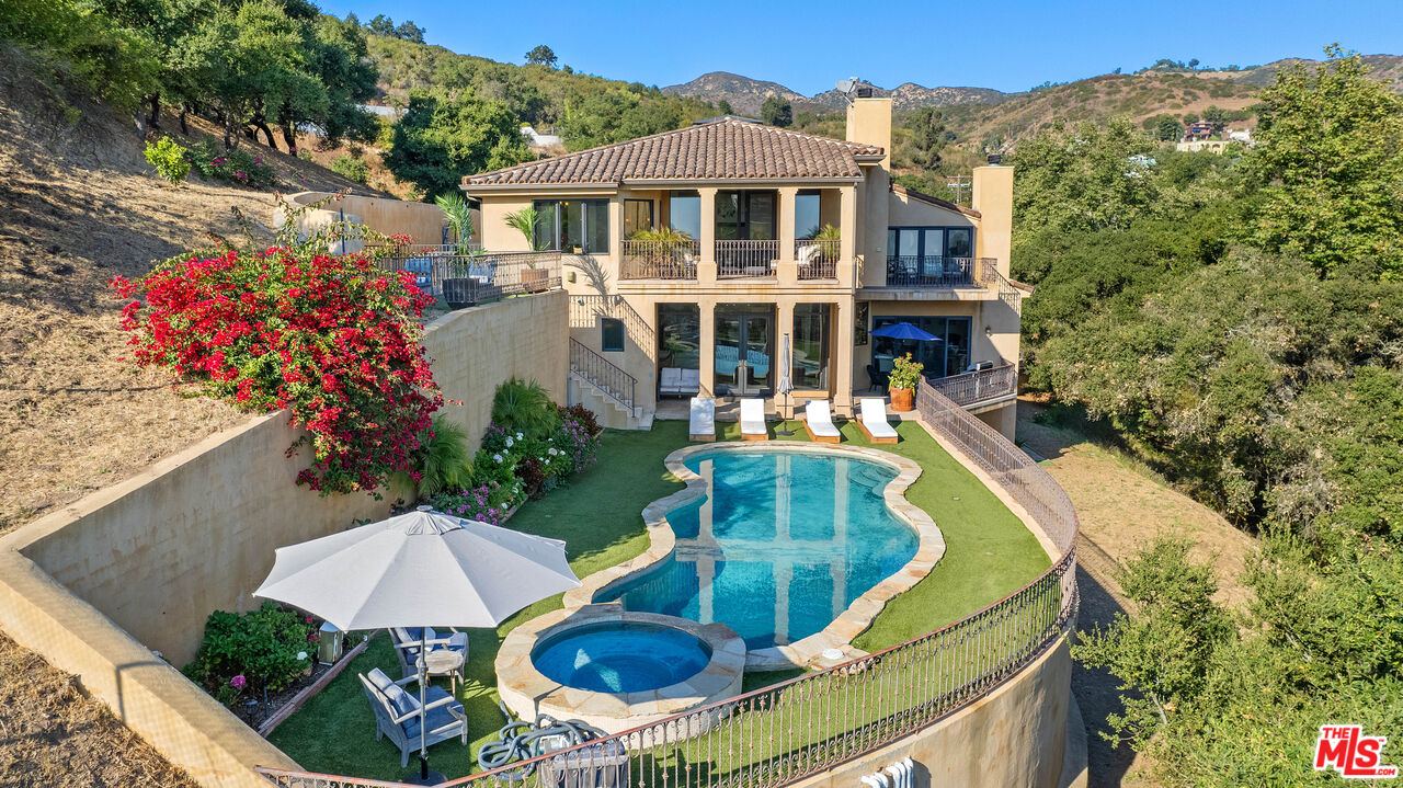 a view of a house with pool and sitting area