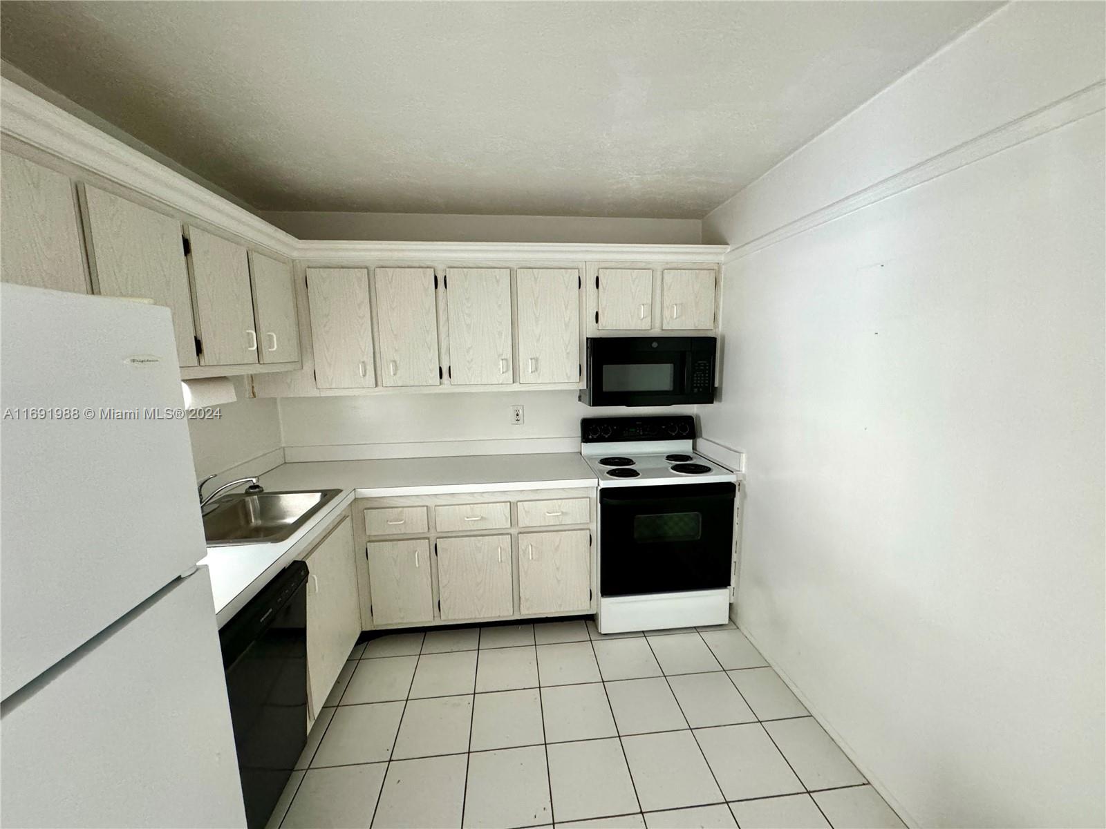 a kitchen with stainless steel appliances a sink a stove a microwave and cabinets