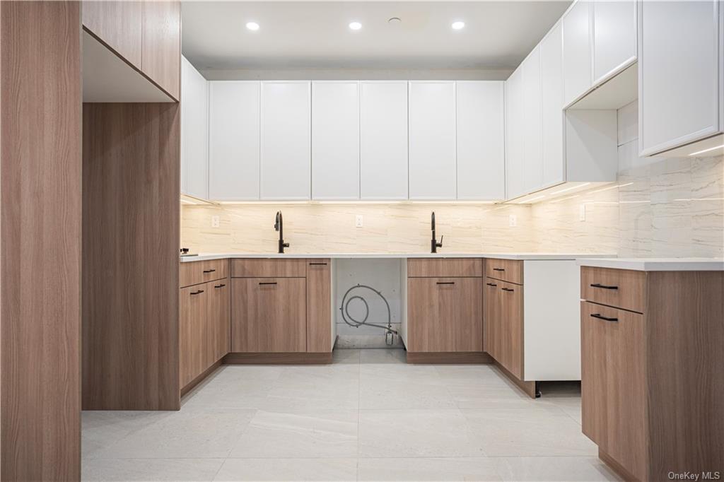 a kitchen with white cabinets and sink