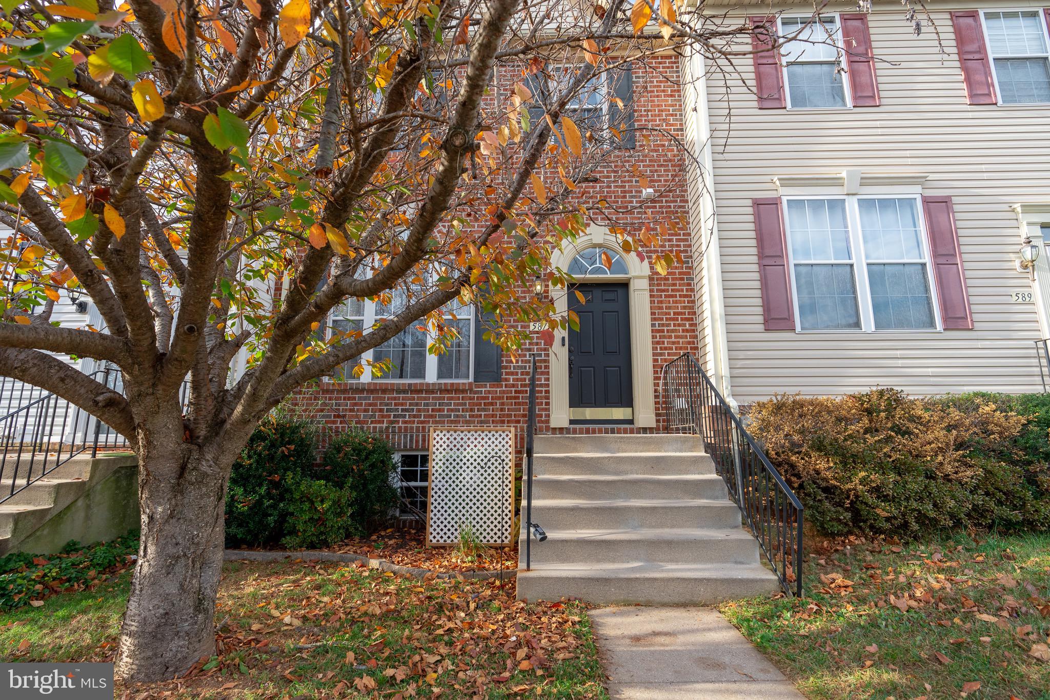 a front view of a house with a tree