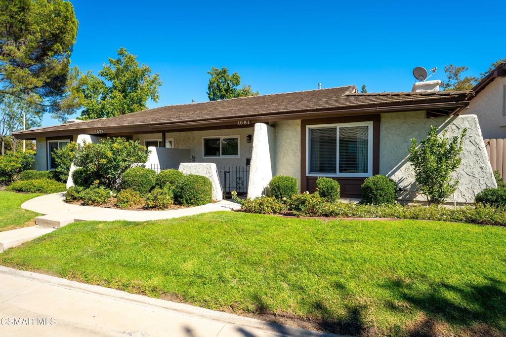 a view of a house with a yard and potted plants