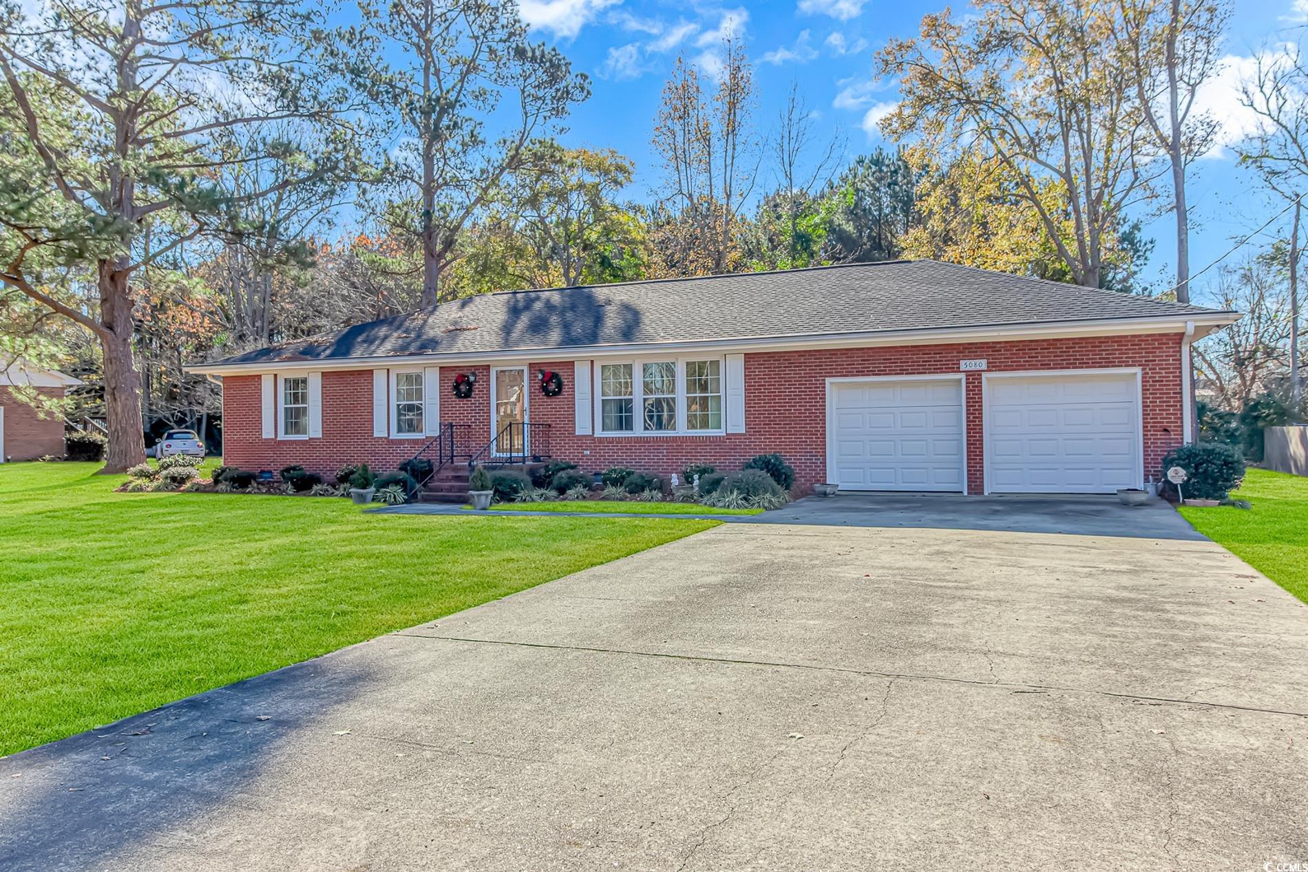 Single story home featuring a garage and a front y