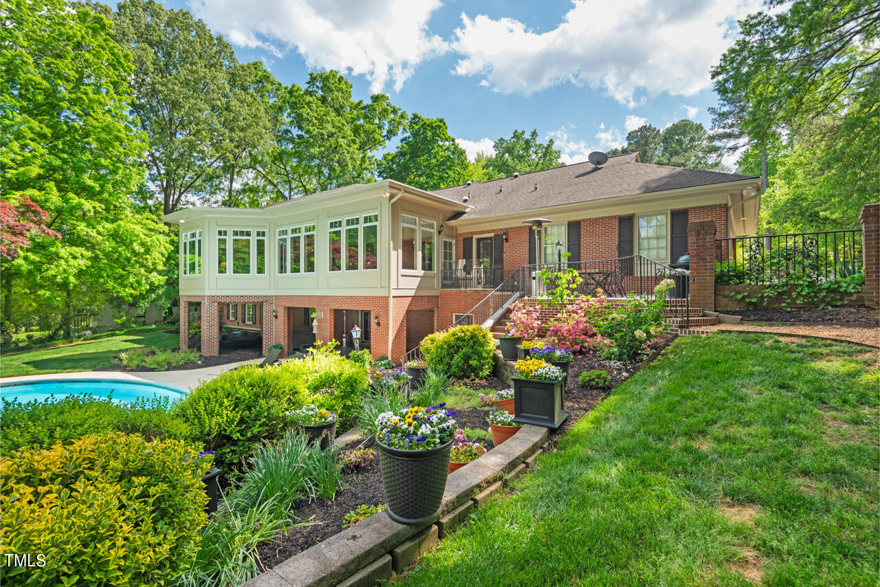 a front view of a house with a yard and potted plants