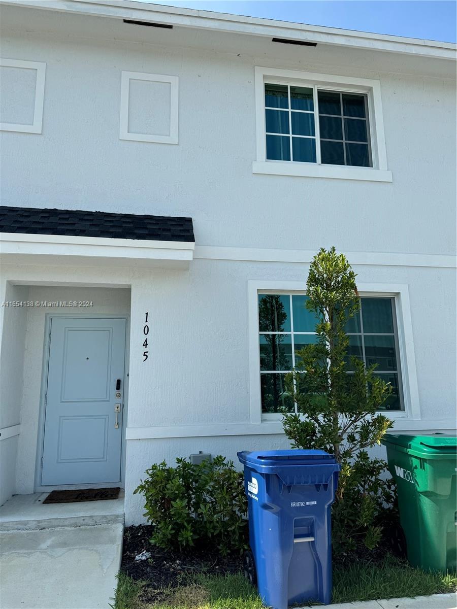 a house with a lot of plants in front of it