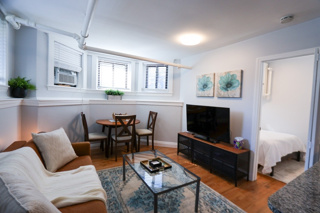 a living room with furniture a rug and a flat screen tv