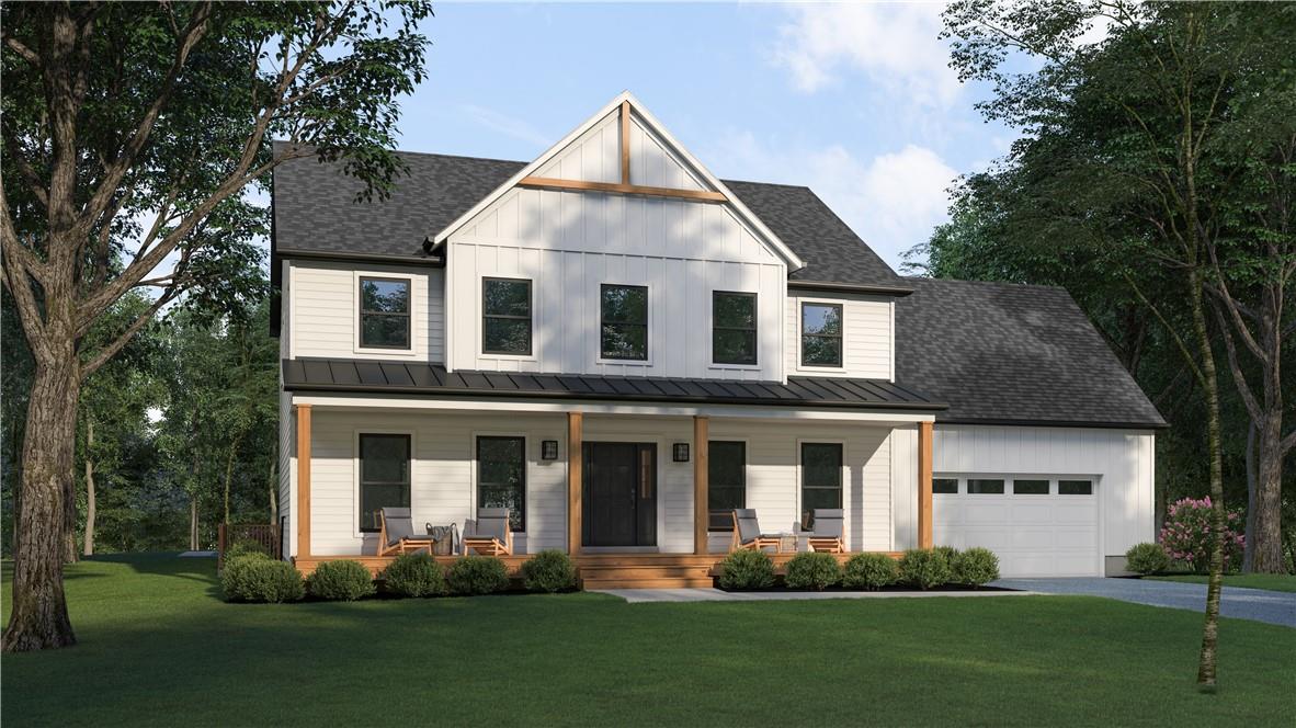 Modern farmhouse featuring a front yard, covered porch, and a garage