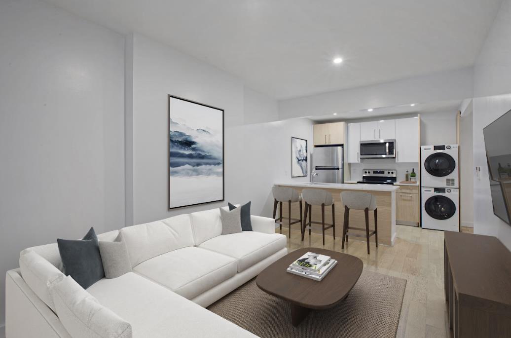 a living room with furniture and kitchen view