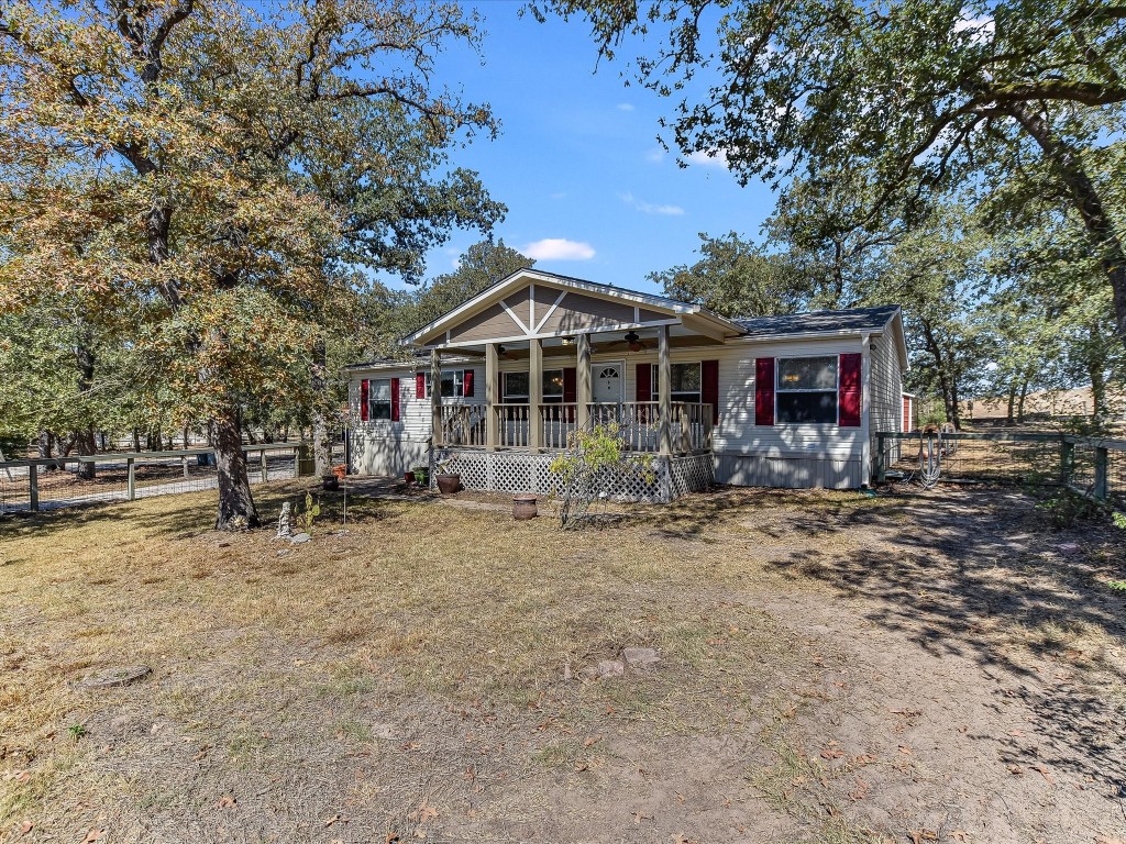 a front view of a house with a yard and trees