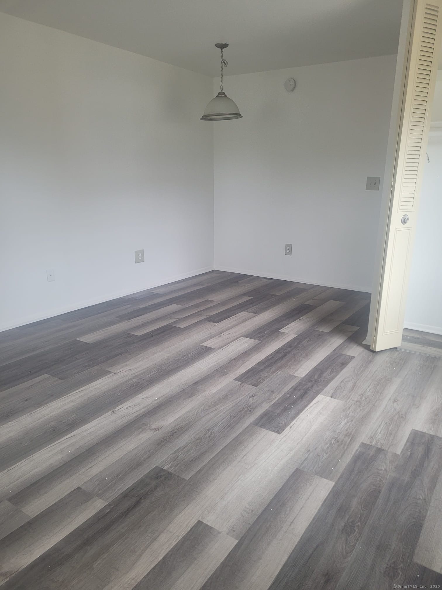 a view of a room with wooden floor and a ceiling fan