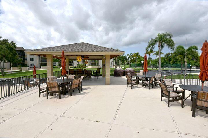 a view of a patio with dining table and chairs with a small yard