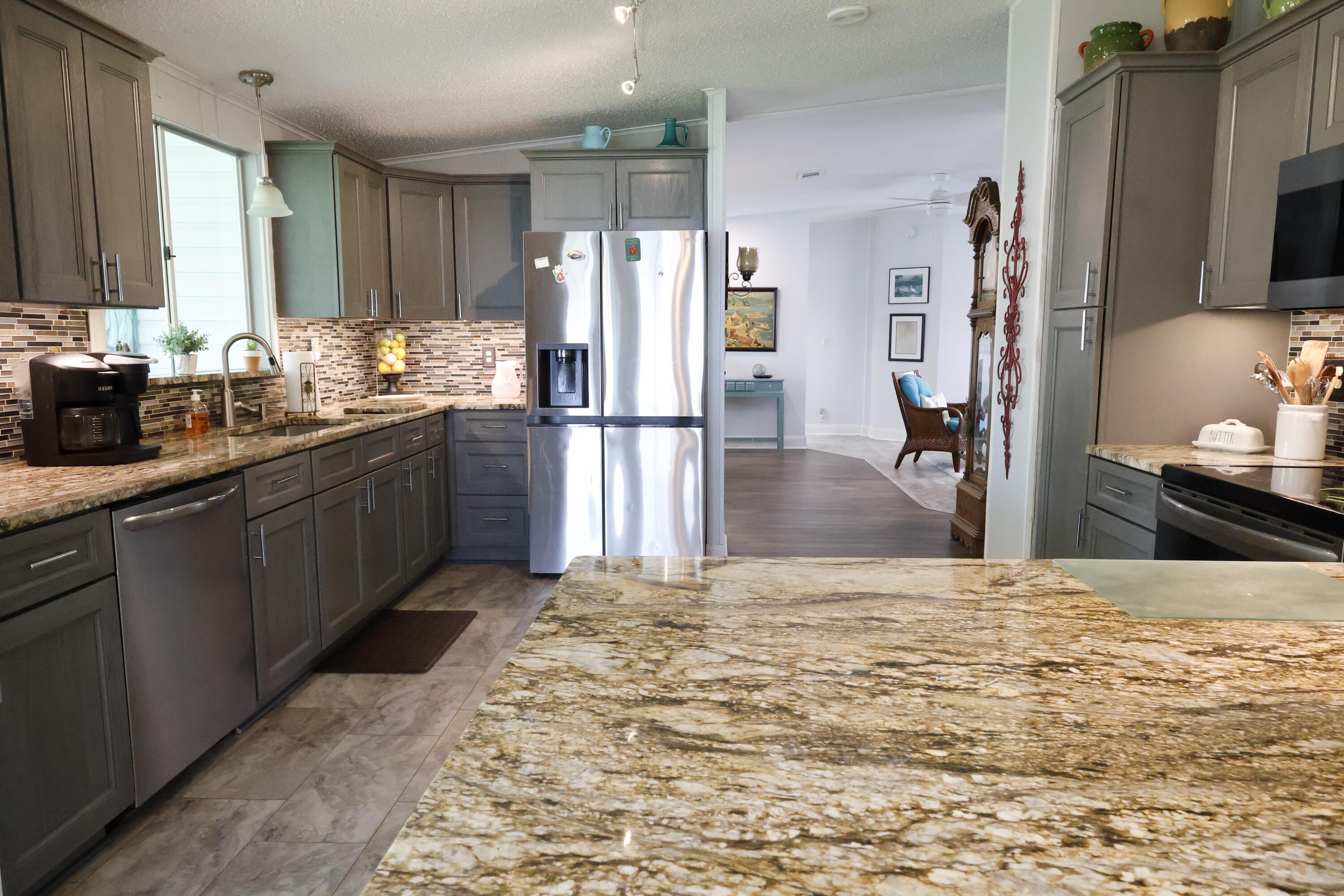 a kitchen with stainless steel appliances kitchen island granite countertop a refrigerator and a sink