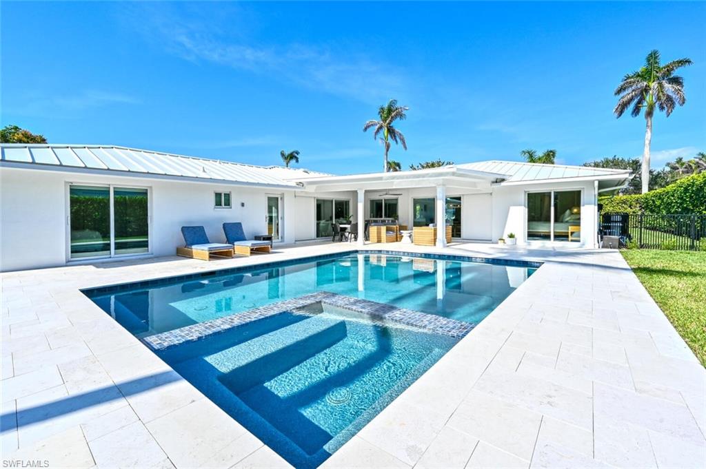 a view of a house with swimming pool and sitting area