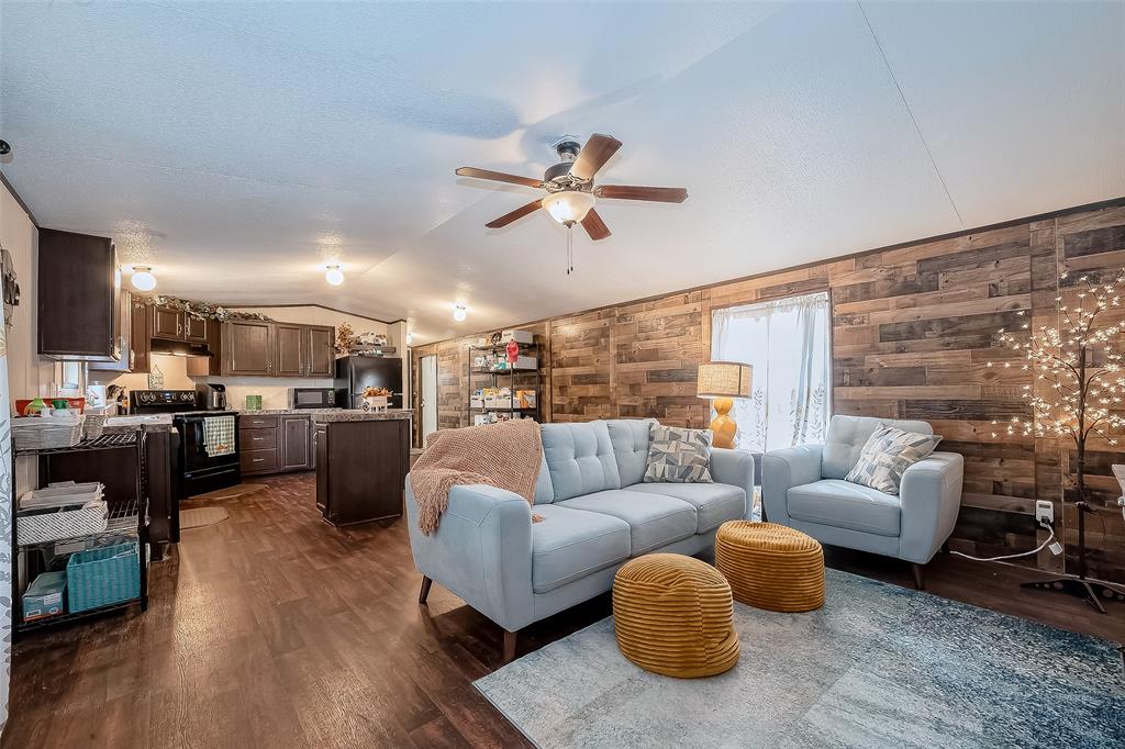 a living room with furniture kitchen view and a chandelier