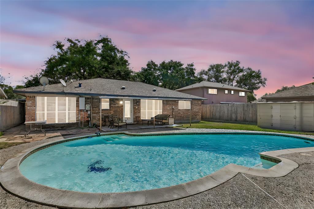 a view of a house with backyard and trees