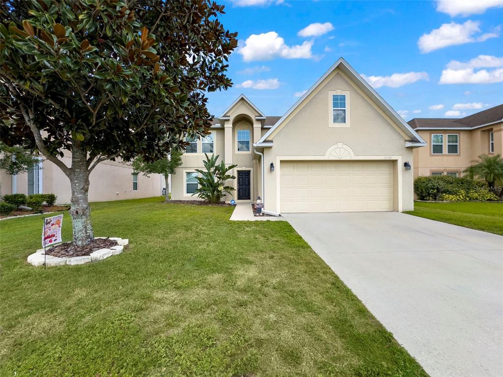 a front view of a house with a yard and garage