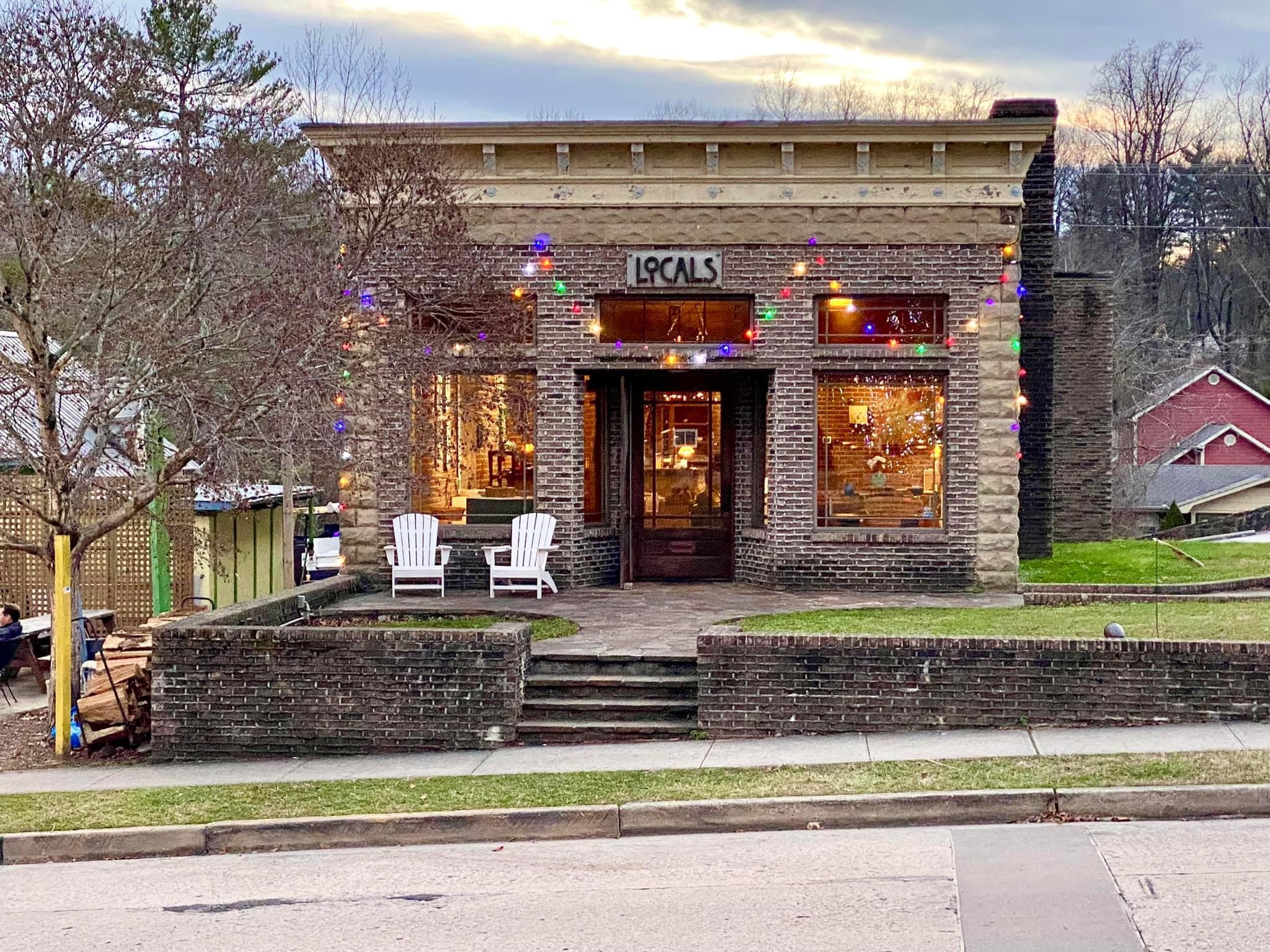 a front view of a house with a yard and potted plants