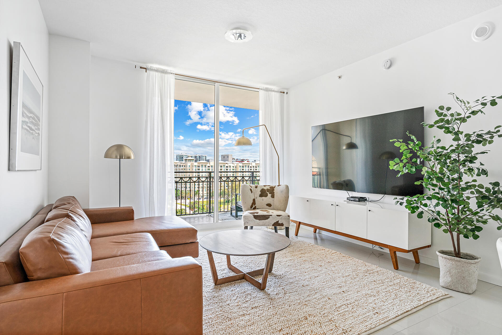 a living room with furniture potted plant and a large window