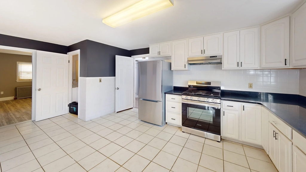 a kitchen with a refrigerator sink and cabinets