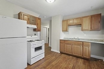 a kitchen with granite countertop white cabinets and white appliances