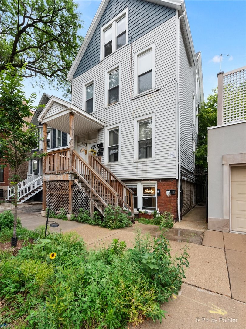 a front view of a house with a yard and potted plants