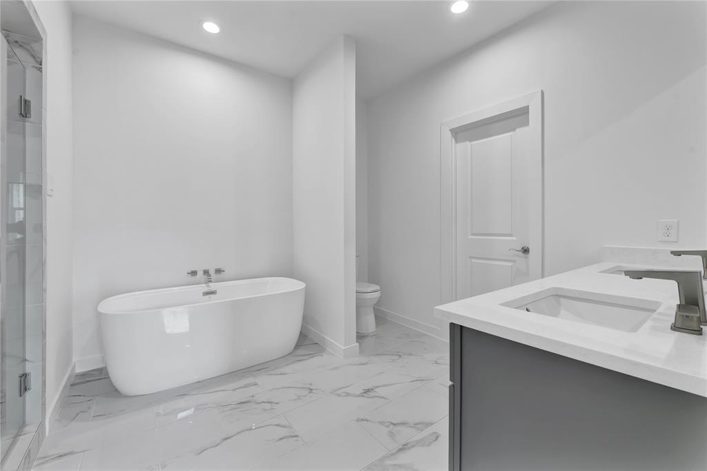 a spacious bathroom with a bathtub sink and mirror