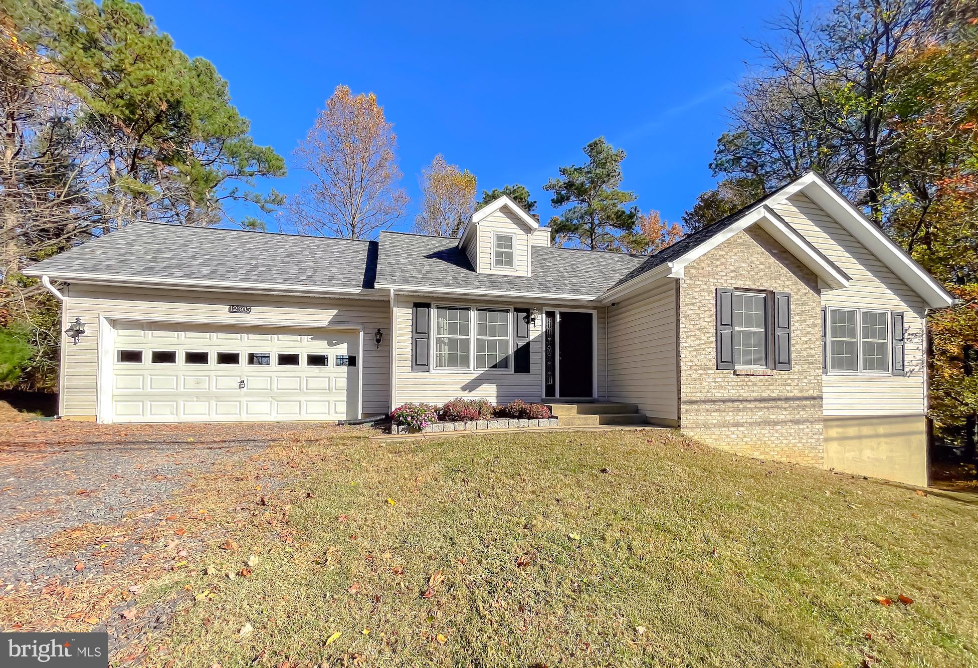 a front view of a house with a garden and yard