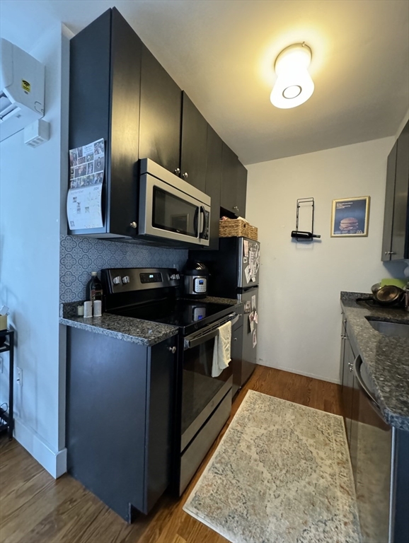 a kitchen with stainless steel appliances granite countertop a stove and cabinets