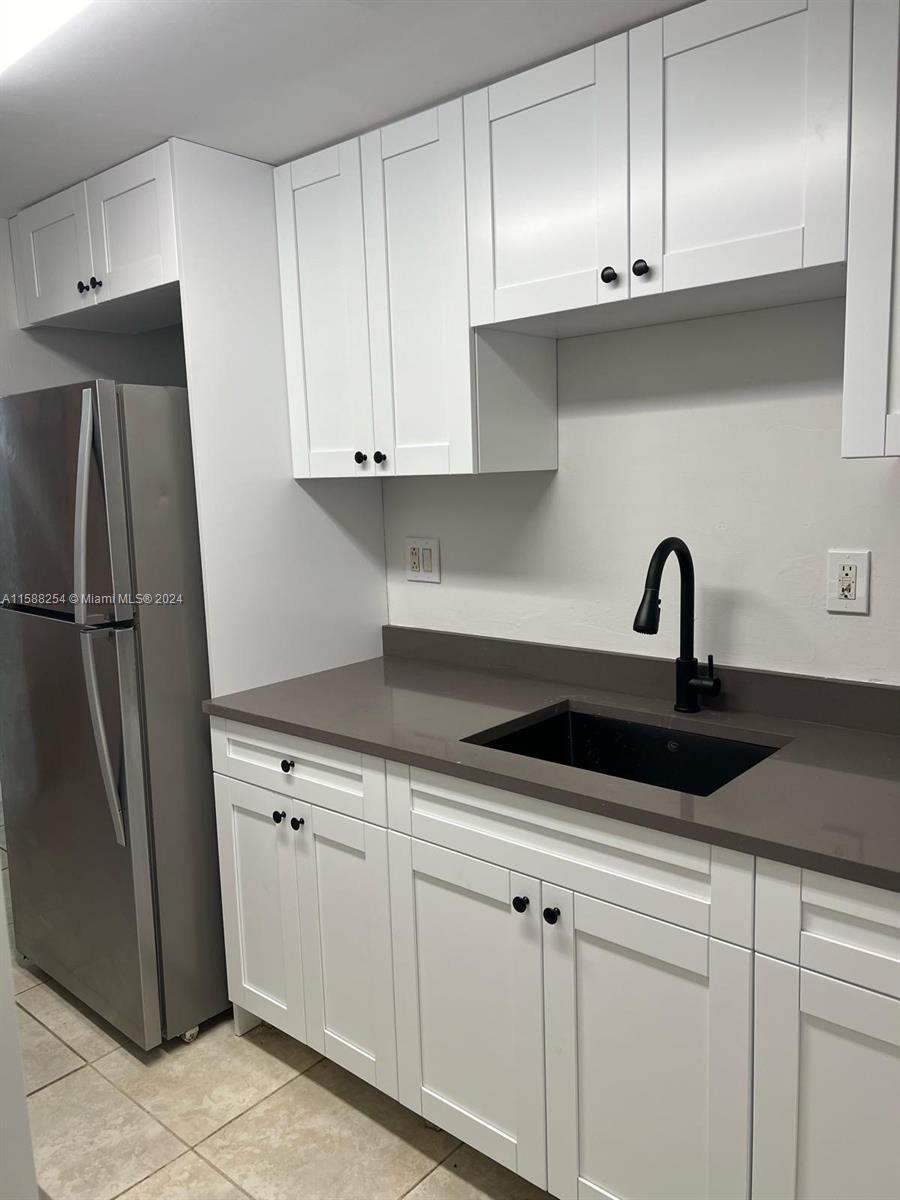 a kitchen with white cabinets and sink stainless steel appliances