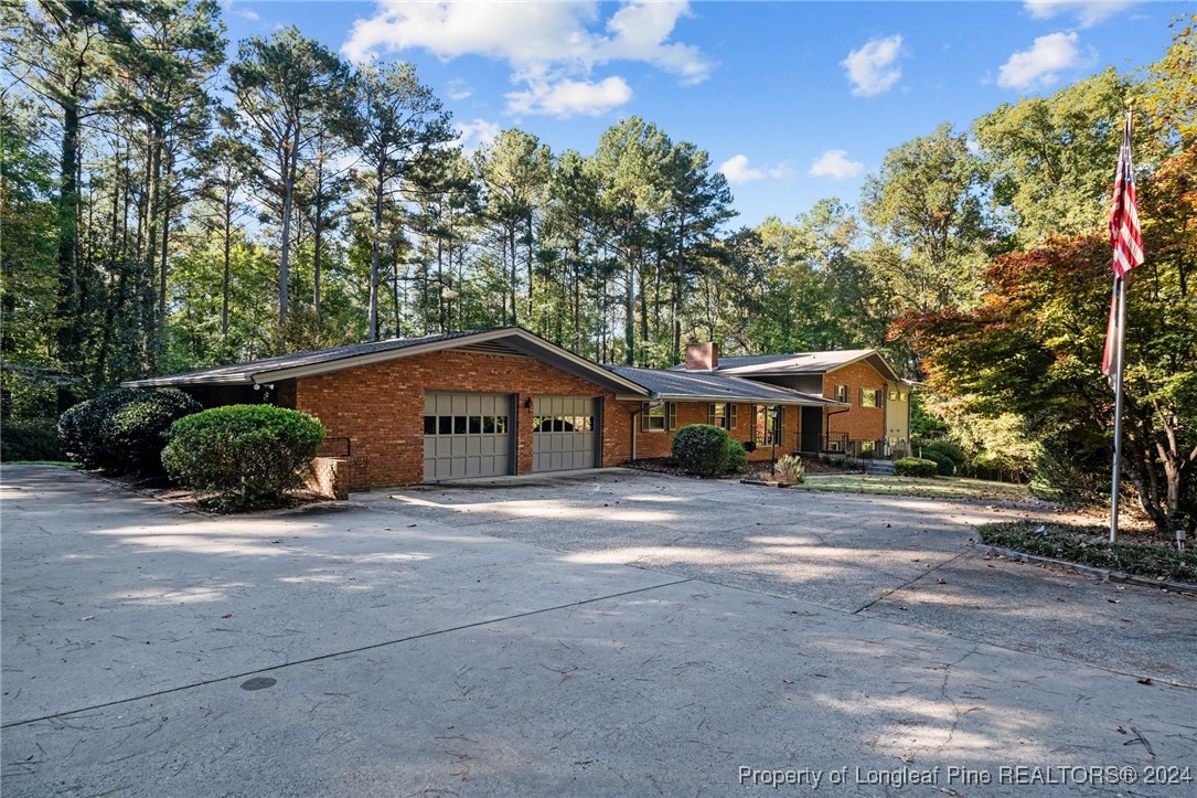 a front view of a house with a yard and trees