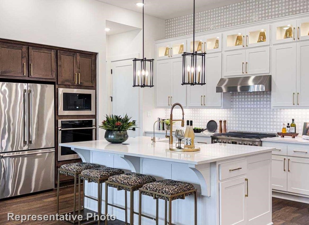 a kitchen with stainless steel appliances granite countertop a stove refrigerator sink and cabinets