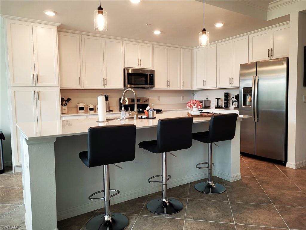 a kitchen with stainless steel appliances granite countertop a sink a stove a refrigerator and cabinets