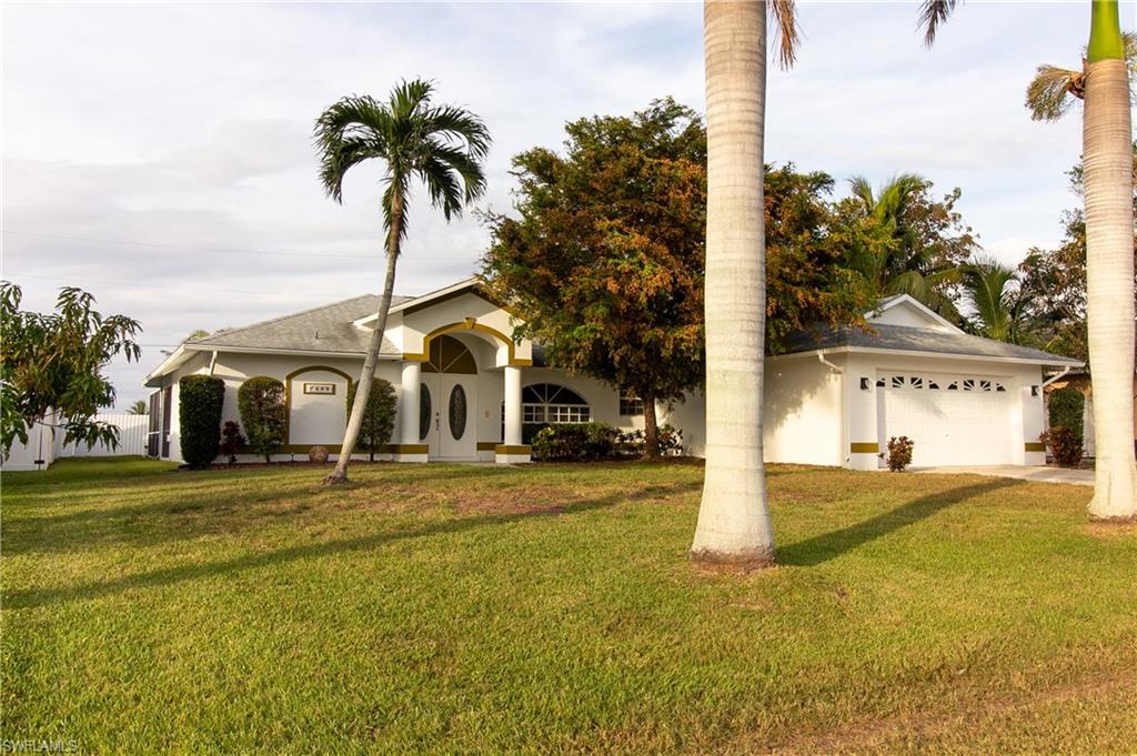 View of front of property featuring a garage and a front lawn