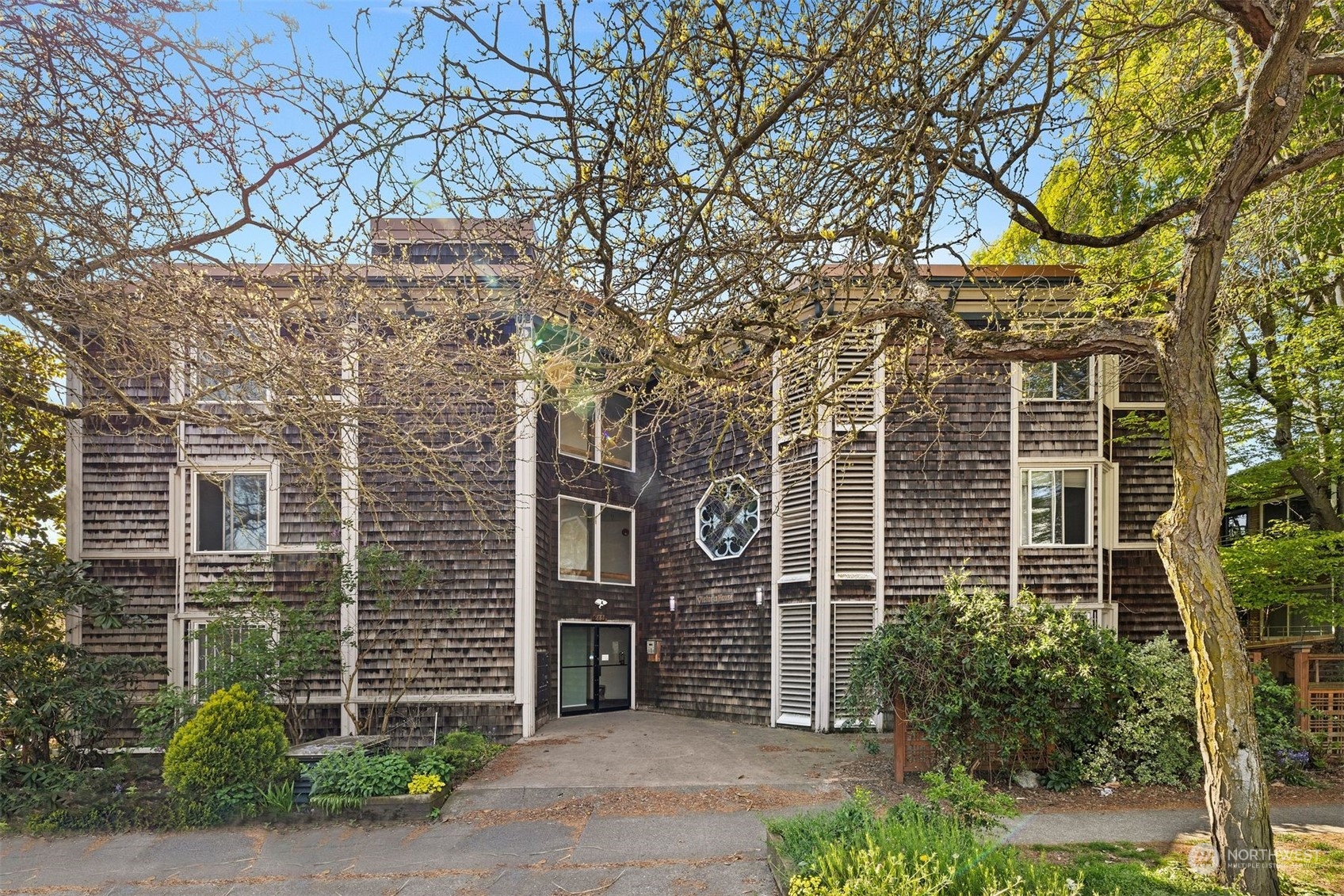 front view of a brick house with a large tree