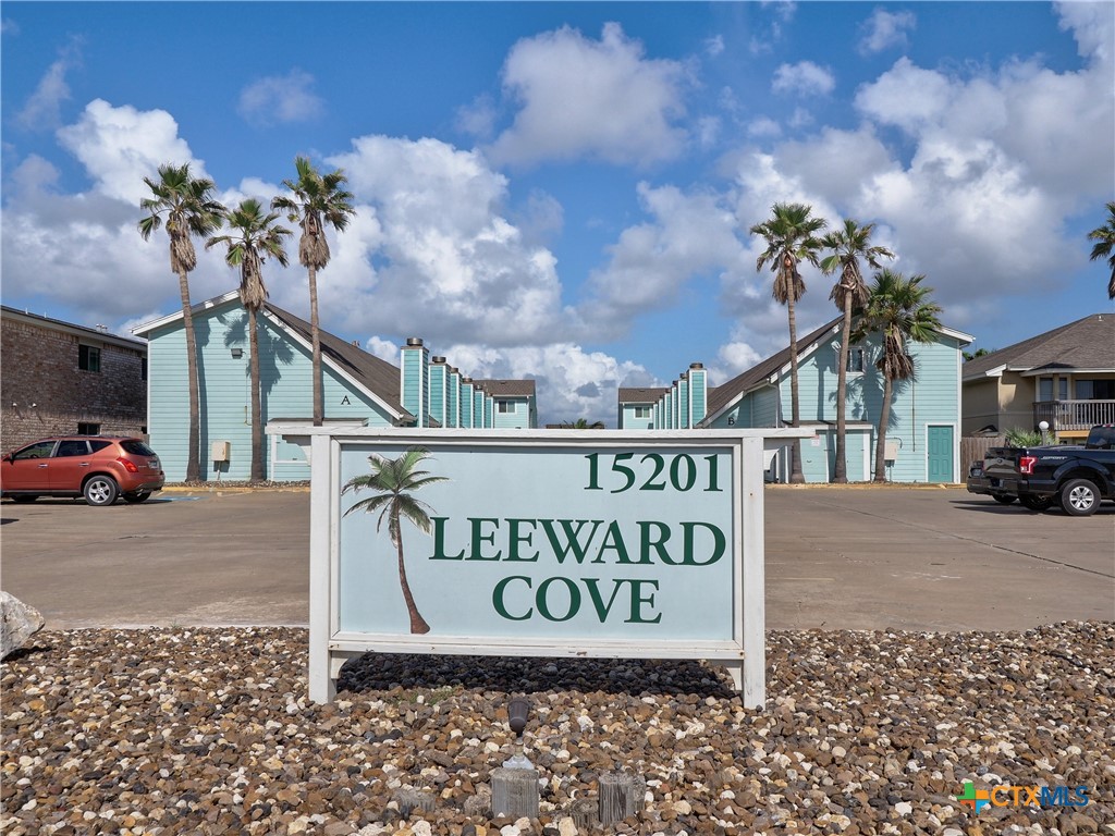 a sign board with a buildings in the background