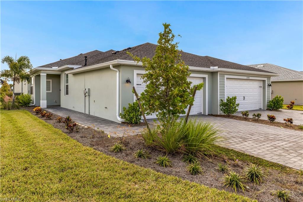 View of side of property featuring a garage and a yard