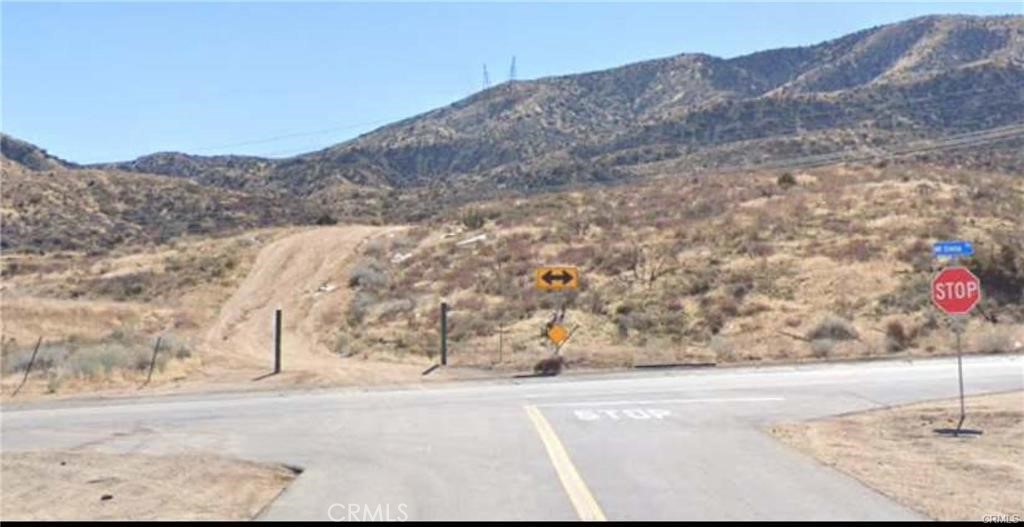 a view of a dry yard with mountains in the background