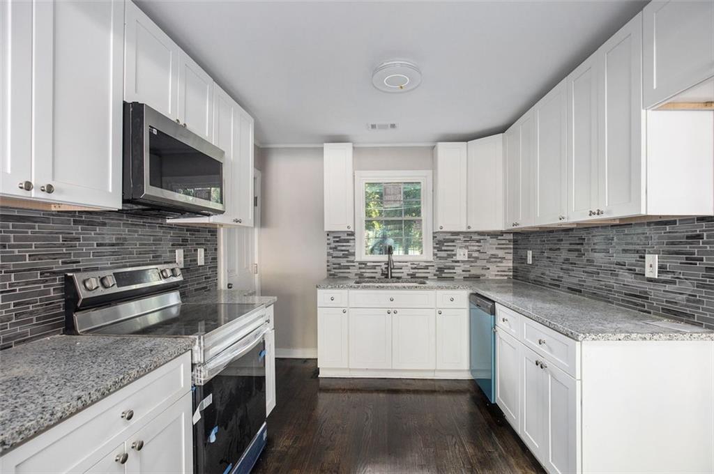 a kitchen with stainless steel appliances granite countertop a sink stove and microwave