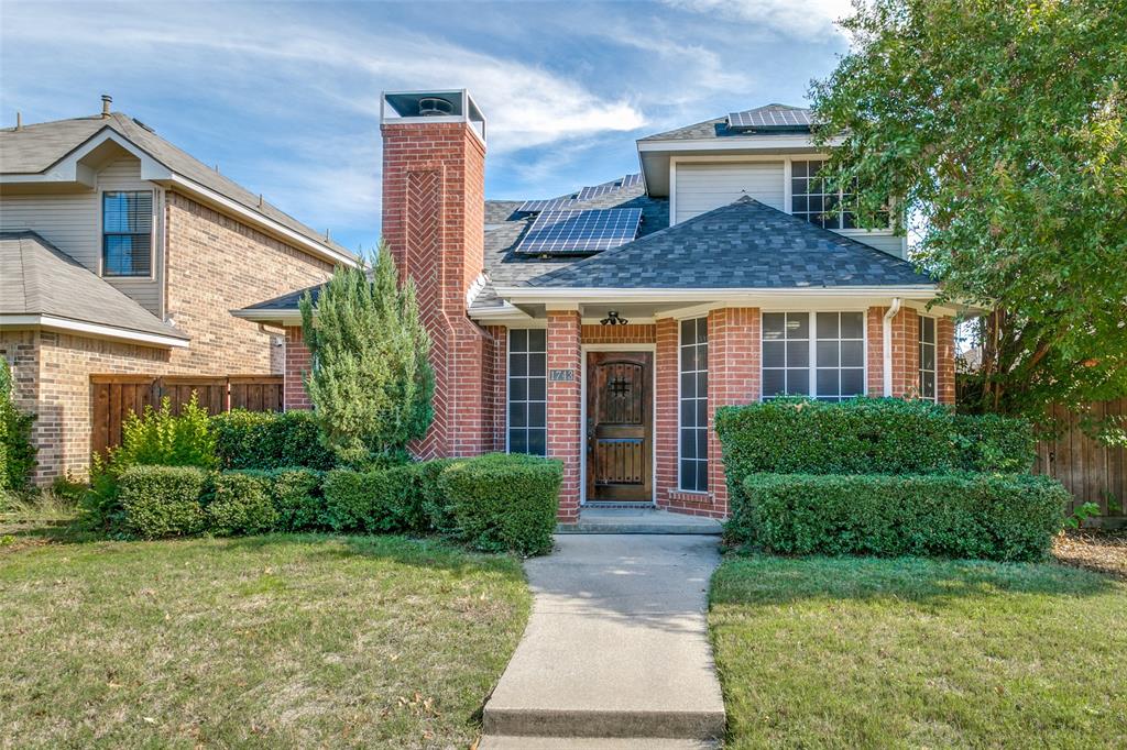 a front view of a house with a yard and plants