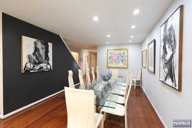 a living room with painting on the wall and wooden floor