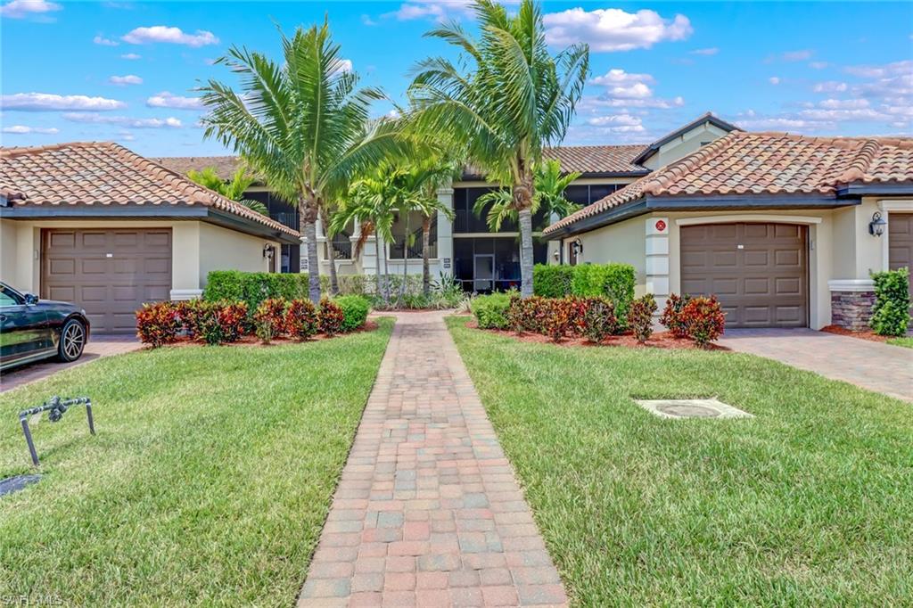 a front view of a house with a yard and potted plants