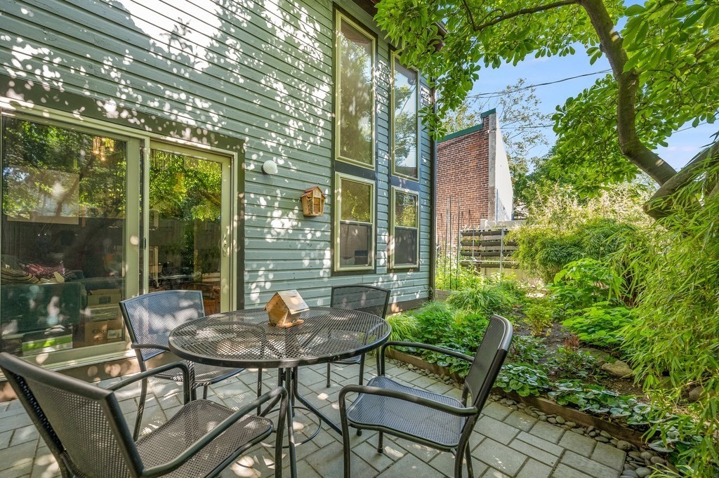 a backyard of a house with table and chairs