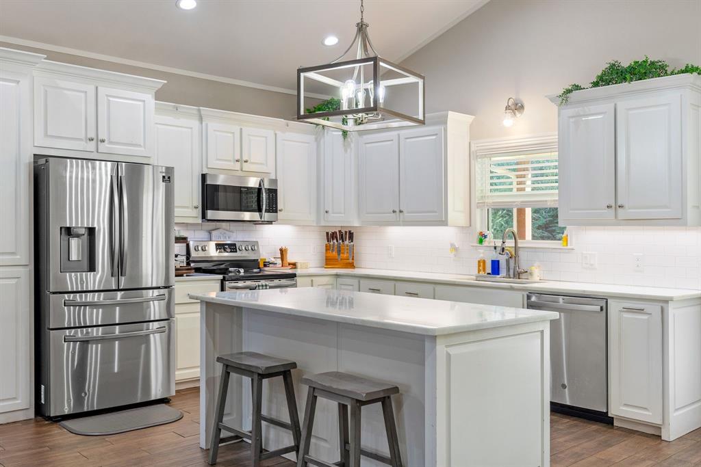 a kitchen with stainless steel appliances a stove a sink island and a refrigerator