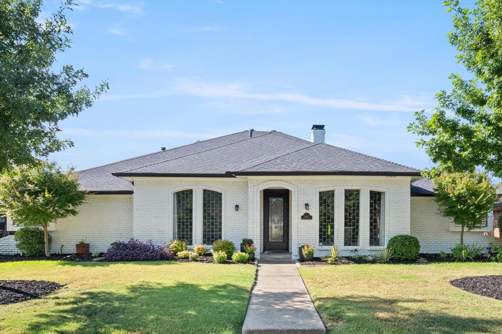 a front view of a house with yard and green space