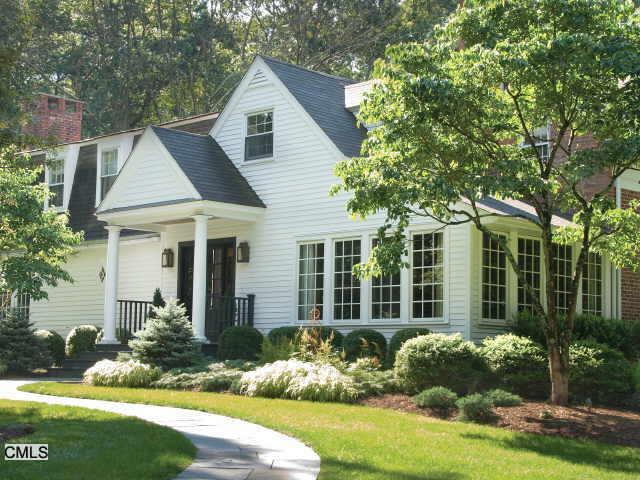 a front view of a house with a yard and potted plants