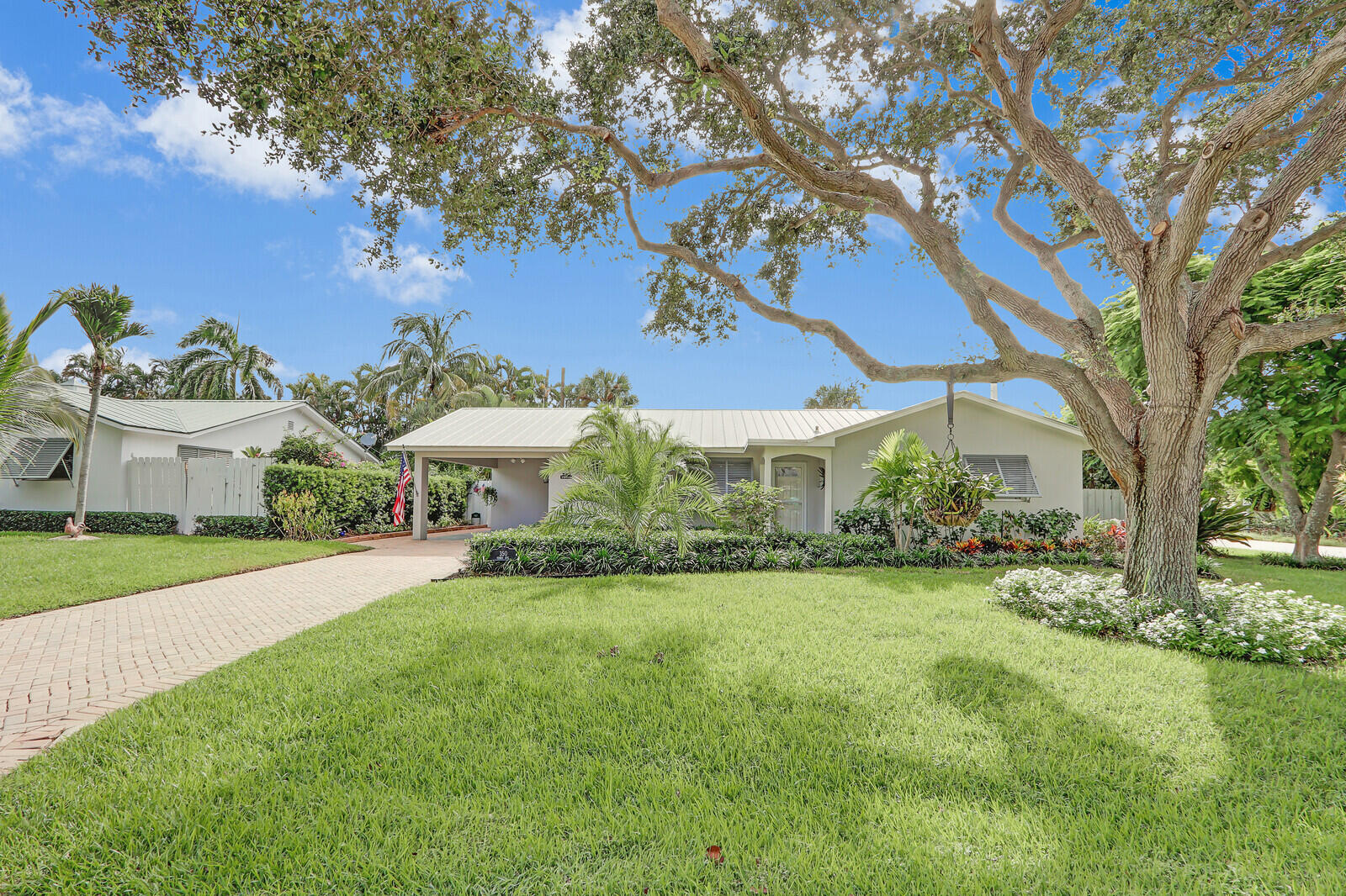 a view of a house with a yard and potted plants