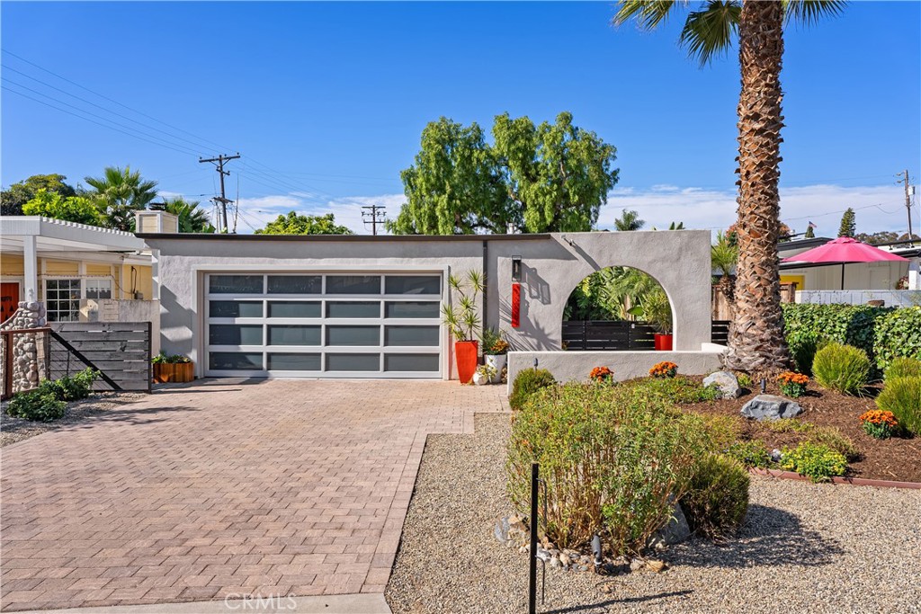 a front view of a house with a yard and potted plants