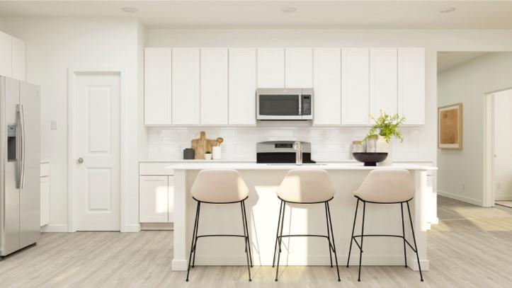 a kitchen with stainless steel appliances granite countertop a table chairs and cabinets