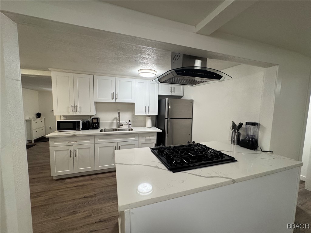 a kitchen with a refrigerator a stove and white cabinets